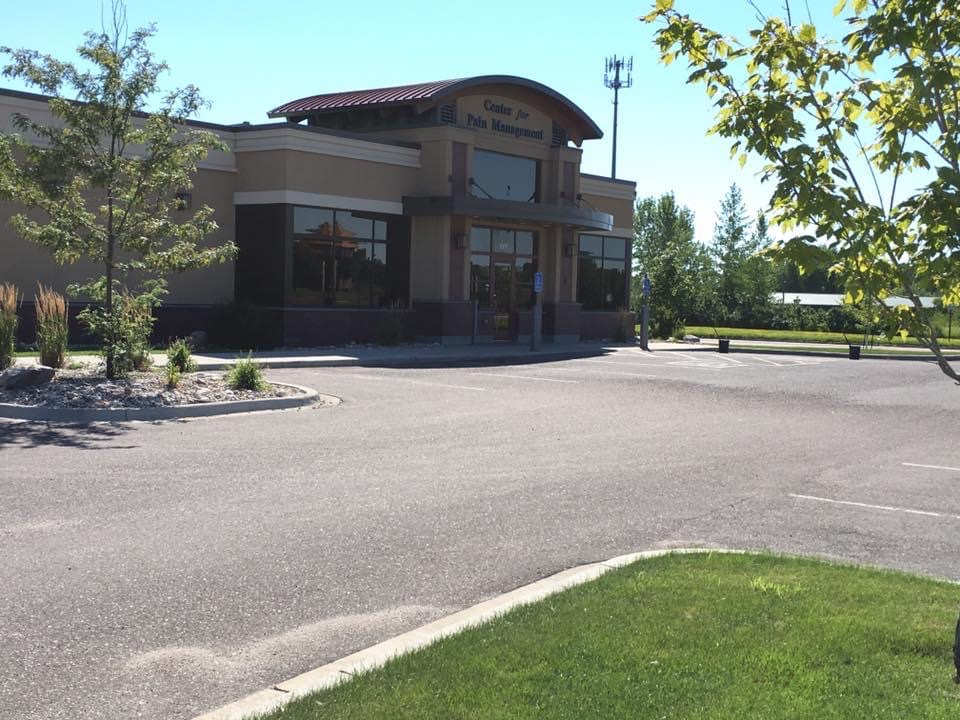 Worn parking lot with faded striping and cracked asphalt before sealcoating