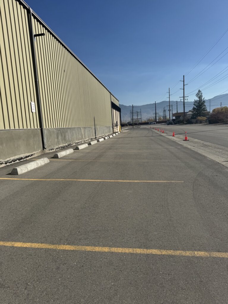 Commercial parking lot shown before and after professional sealcoating and striping