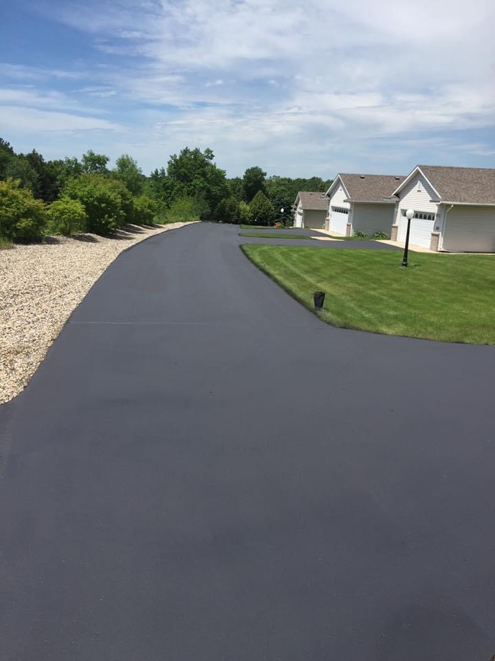 Long Driveway Sealcoated residential driveway in front of a single-family home