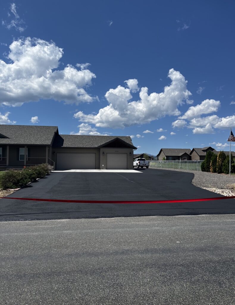Before and after images of a residential asphalt driveway sealcoating project
